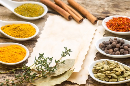 Diversity of Spices on wood background with blank paper sheet.の写真素材