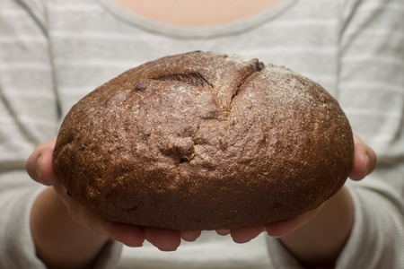 Fresh baked rye bread in female hand