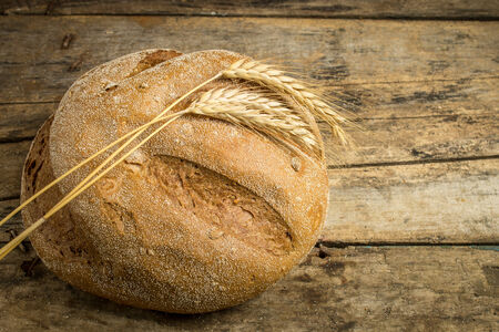 Bakery background. Whole wheat bread on wooden tableの写真素材