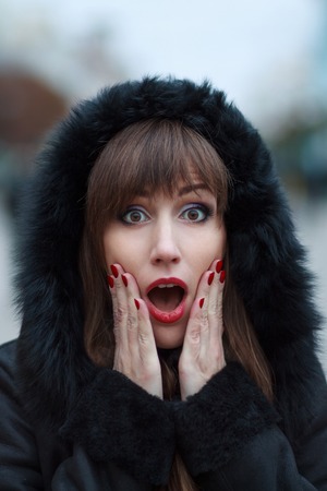 Young beautiful surprised girl at winter outdoor. Amazed womanの写真素材