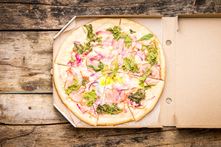 Fast food pizza background. Top view mock up with pizza in box on wooden table.の写真素材