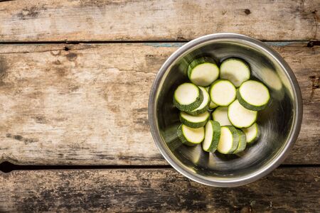 Vegetarian recipe or menu background with copy space. Sliced zucchini in a bowlの写真素材
