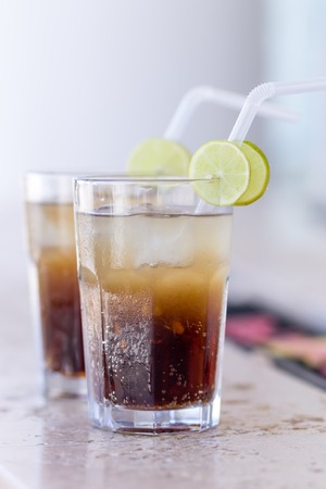 Two glasses of exotic cocktail with straw and decorated with lemon