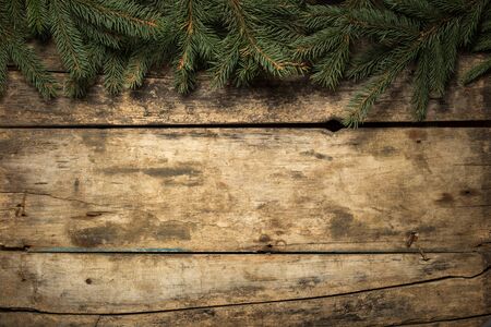 Christmas decorative background. Fir tree branches with bows and snowflakes on wooden backgroundの写真素材