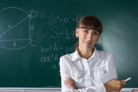 Young teacher woman or student girl at the blackboard with math equationの写真素材