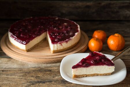 Piece of cheesecake with mandarins on wooden table. Recipe or breakfast menu backgroundの写真素材
