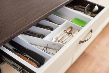 Spoons, forks and knives in cutlery box drawer in kitchen cupboard.の写真素材