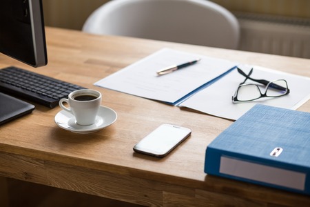 Business workplace background with computer, documents and cup of espressoの写真素材