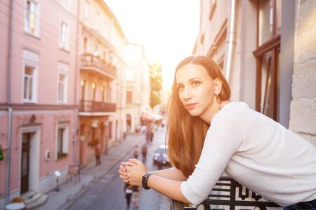 Young beautiful woman standing on the balconyの写真素材