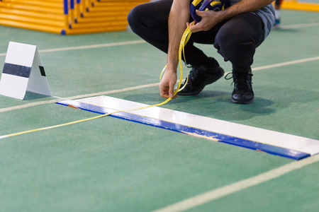 An official taking measure of long or triple jumpの写真素材