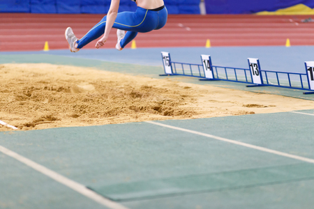 Girl jumping into sandpit on long jump competitionの写真素材
