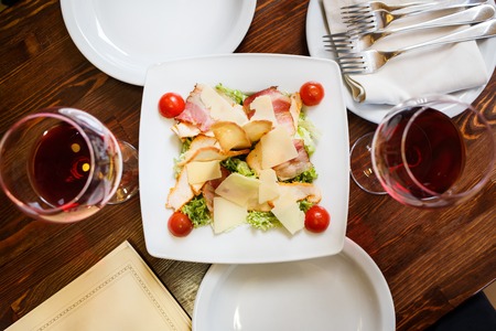 Caesar salad served on white plate in restaurantの写真素材