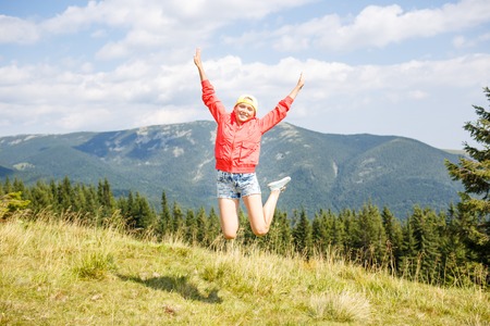 Young teenage girl jumping in mountains