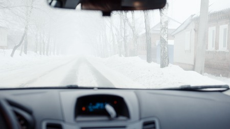 Bad weather driving with low visibility in winter. Thick fog on the roadの写真素材