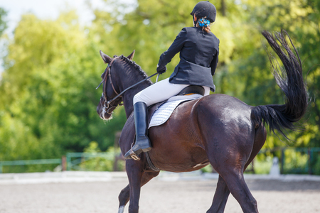 Young girl riding horse on equestrian competitionの写真素材