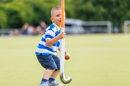 Small funny boy playing field hockeyの写真素材