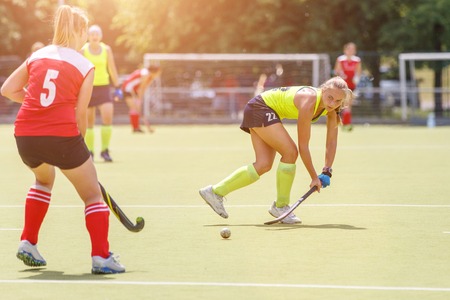 Young hockey player hit the ball in field hockey gameの写真素材