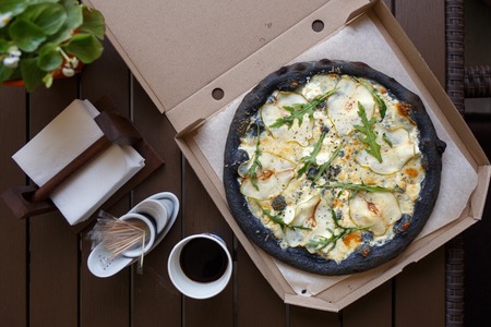 Black pizza four cheese with coffee top view imageの写真素材