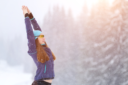 Young woman stretching before road running in winter. Sporty girl warming up before joggingの写真素材
