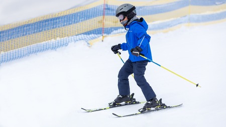 Small boy skiing on slope at mountain ski resortの写真素材