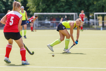 Young hockey player hit ball in field hockey gameの写真素材