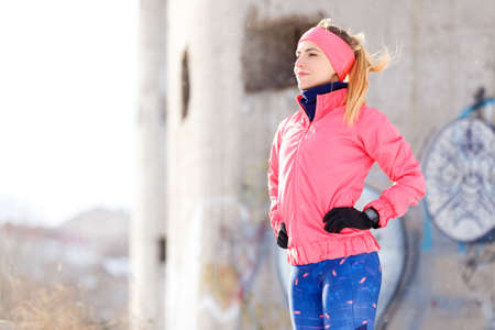 Portrait of young smiling sporty woman standing outdoors.の写真素材