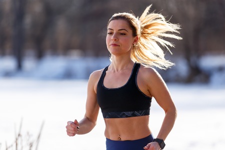 Young woman in top running in cold weatherの写真素材