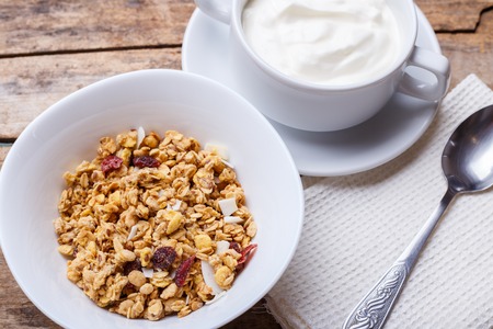 Healthy breakfast background. Muesli with yoghurt in bowl on wooden backgroundの写真素材