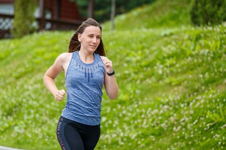 Young woman running in mountain european town in the morning
