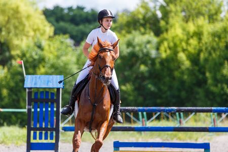 Young girl riding horse on equestrian sport showの写真素材