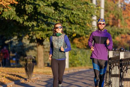 Runners fitness couple running in the city park. Active couple jogging outdor in the morningの写真素材
