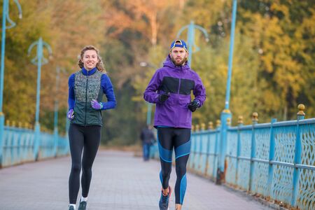Runners fitness couple jogging in the city parkの写真素材