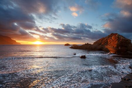 Sunset at the black beach of Tenerife in oceanの写真素材