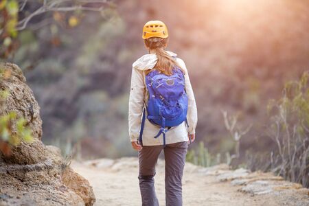 Young woman hiking in mountains with backpack