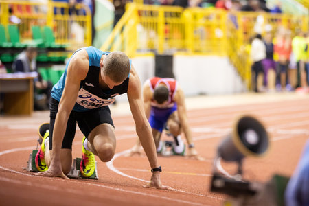 SUMY, UKRAINE - FEBRUARY 21, 2020: sportsmen at the start of 400m race at Ukrainian indoor track and...