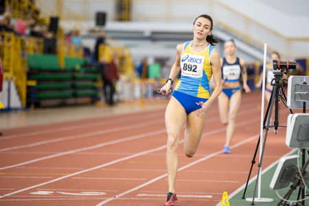 SUMY, UKRAINE - FEBRUARY 22, 2020: sportswomen running 4x400m relay at Ukrainian indoor track and...