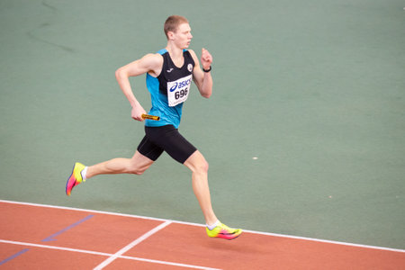 SUMY, UKRAINE - FEBRUARY 22, 2020: sportsman running 4x400m relay at Ukrainian indoor track and field championship 2020.のeditorial素材