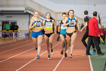 SUMY, UKRAINE - FEBRUARY 22, 2020: sportswomen running 4x400m relay at Ukrainian indoor track and field championship 2020.のeditorial素材