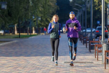Young couple run on the street in the morning. Healthy jogging lifestyle backgroundの写真素材