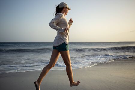 Young woman having fun at the ocean beach with black sandの写真素材