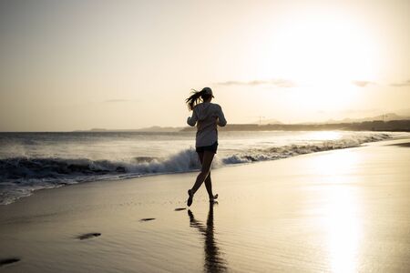 Young woman having fun at the ocean beach with black sandの写真素材