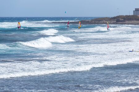 Surfers and windsurfers on the waves of El Medano, Tenerife, SPainの写真素材