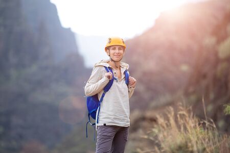 Young woman with backpack enjoying mountains on trekking trip in volcanic ravine on Tenerife, Spainの写真素材