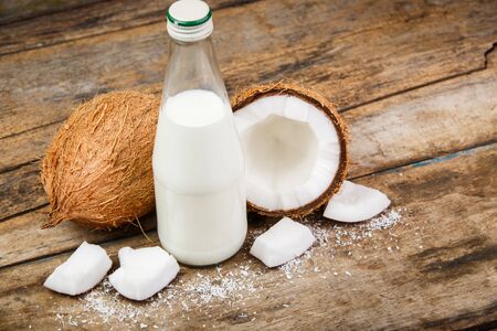 Concept image of coconuts with bottle of milk on woodの写真素材