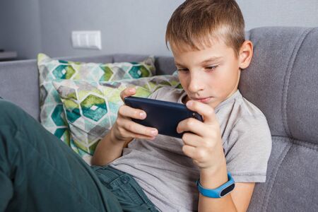 School boy sitting at home watching online education classの写真素材