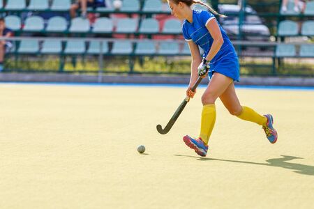 Field hockey female player lead the ball in attack in the gameの写真素材