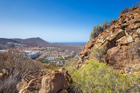 Landscape of volcanic hills with view on atlantic ocean and town of Palm-mar, Tenerife, Spainの写真素材