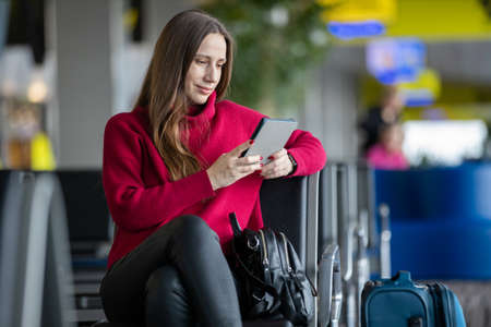 Young woman reading book waiting for the flight at the airportの写真素材