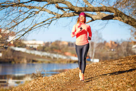 Slim woman running in the morning in the parkの写真素材