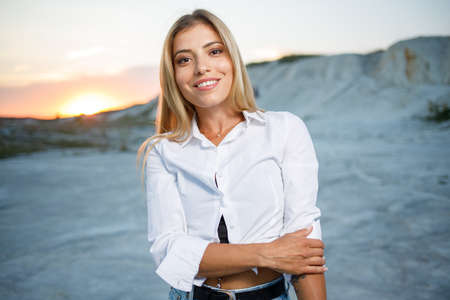 Young beautiful blonde woman with healthy teeth posing outdoorsの写真素材